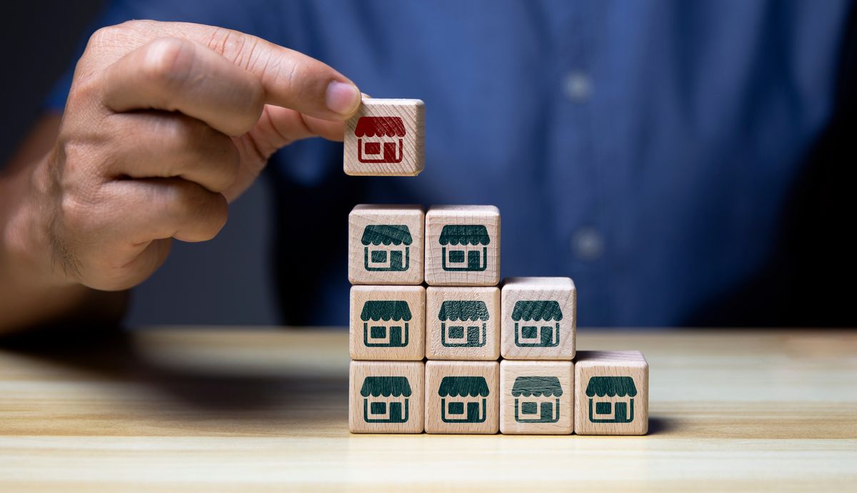 Man with building blocks representing insurance agency franchises