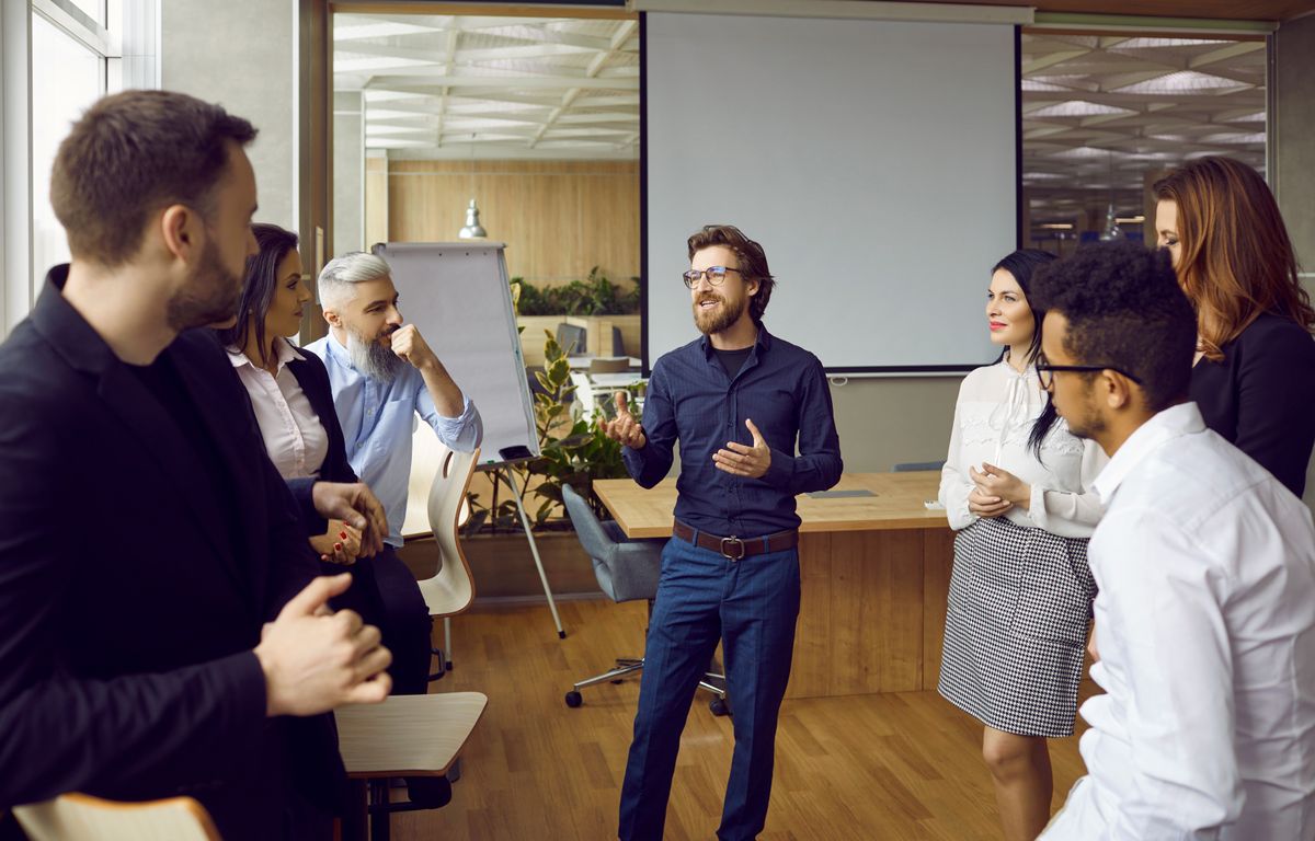 Manager talking to a group of listening employees