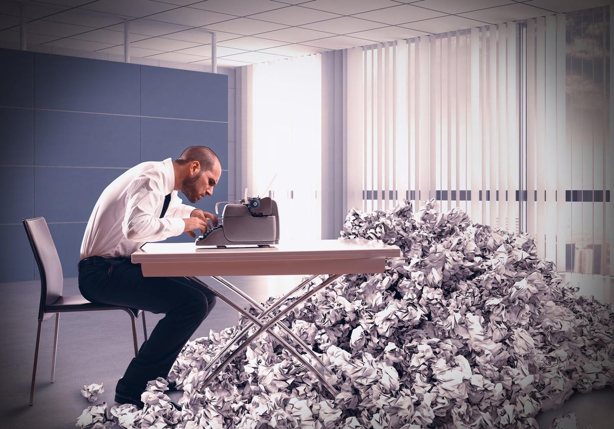 Overworked exhausted businessman writes with a typewriter
