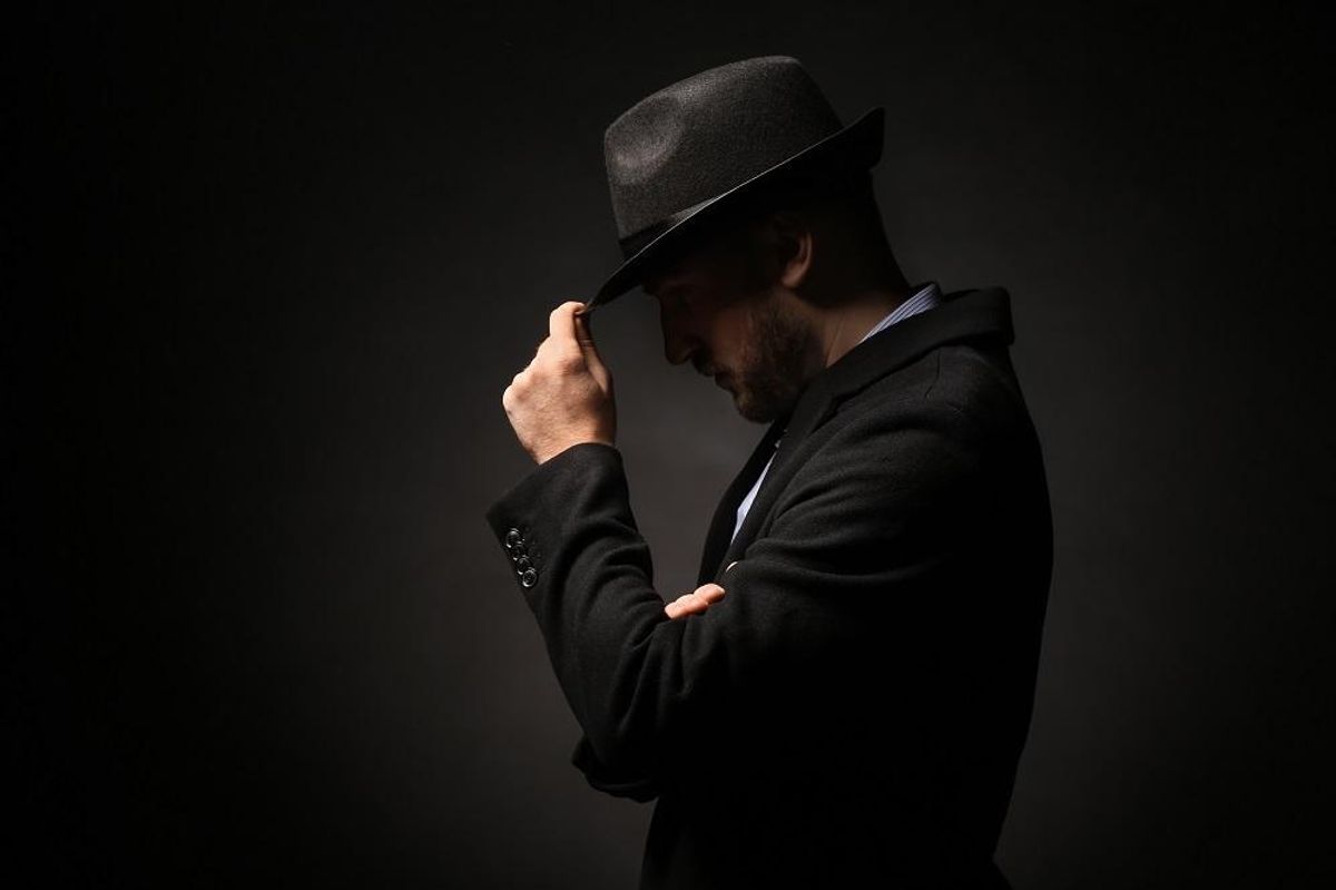 Portrait of detective on dark background