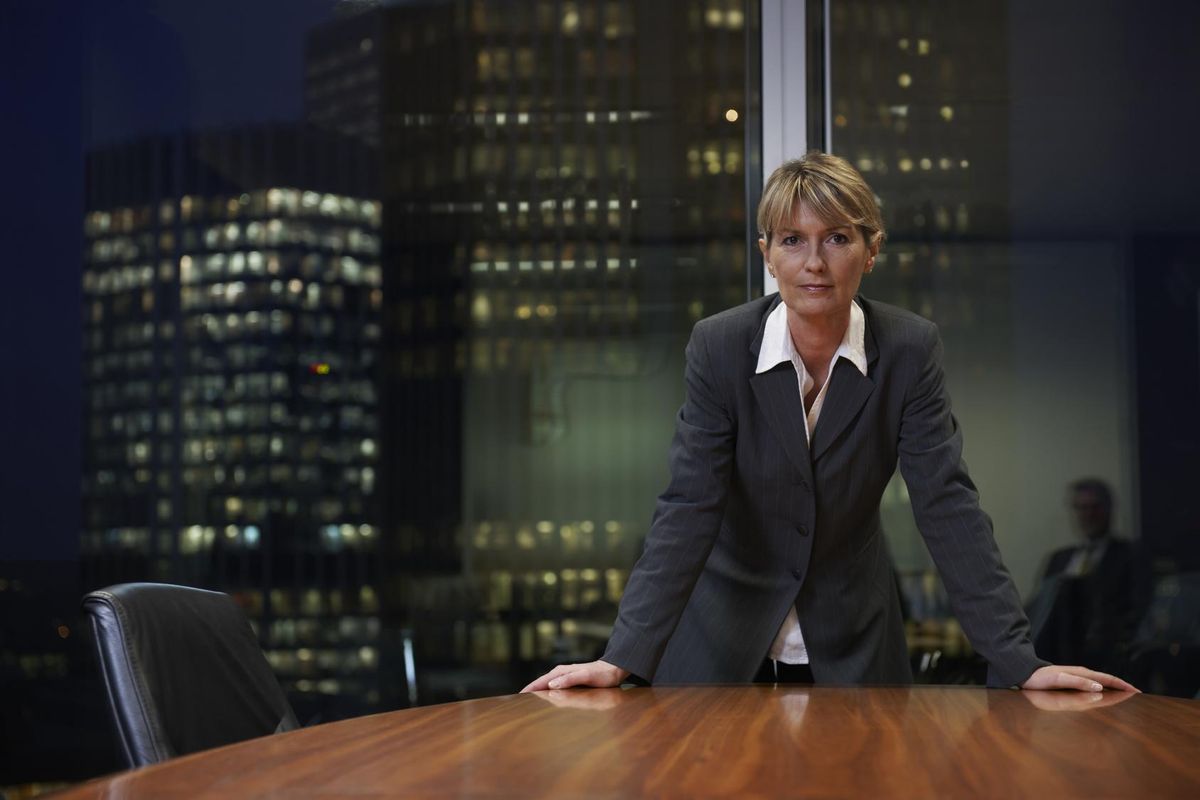 Senior Business woman leaning on table in boardroom