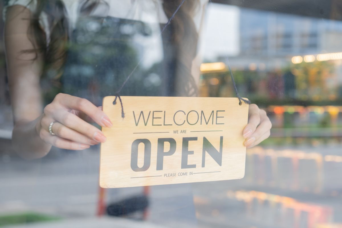 Small business owner opening shop after avoiding common mistakes