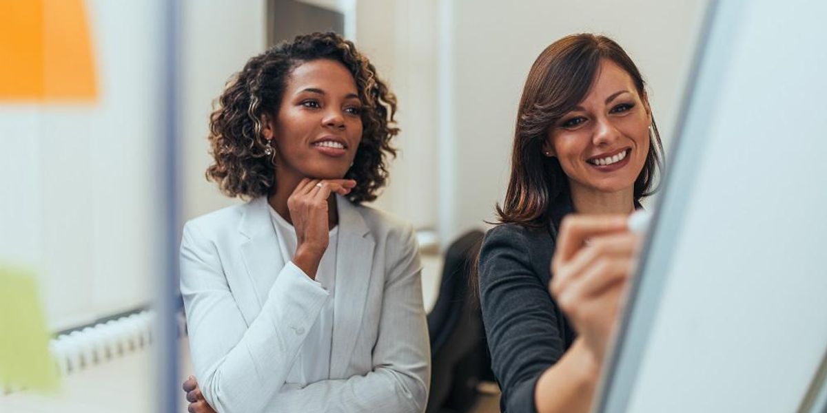 Smiling entrepreneurs working together to find solutions.