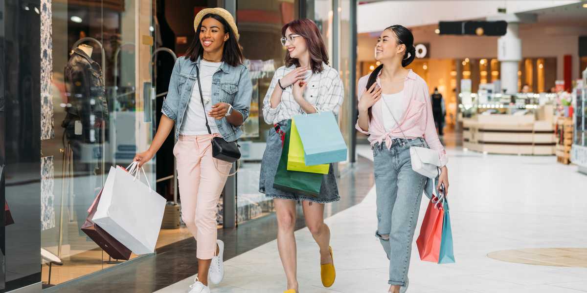 Smiling Gen Z girls shopping
