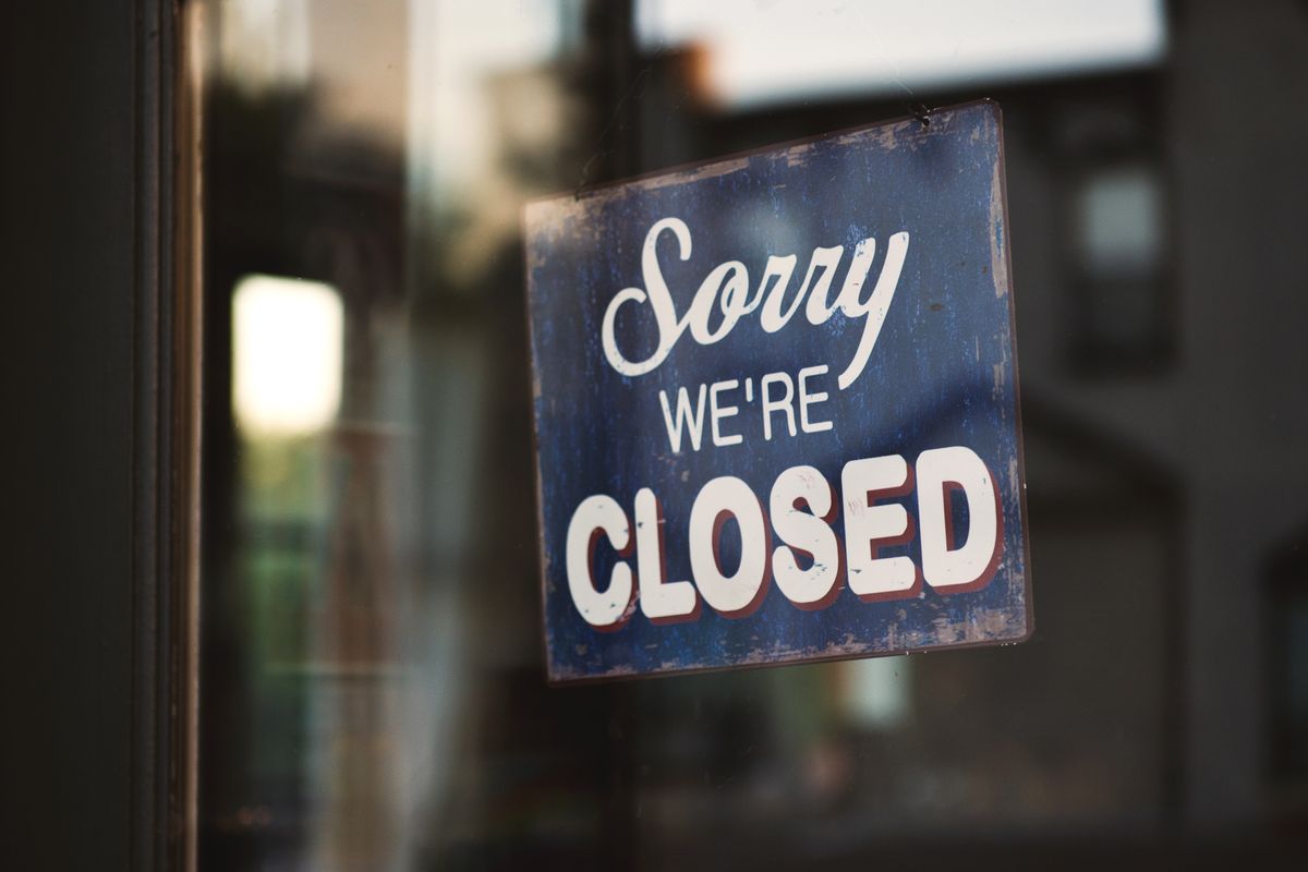 Steps to dissolving a company -- Sorry we're closed signage hanged on glass door