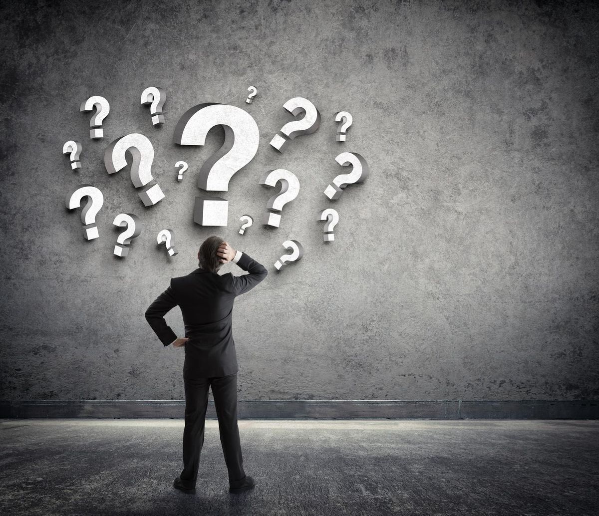 Thoughtful businessman with questions marks
