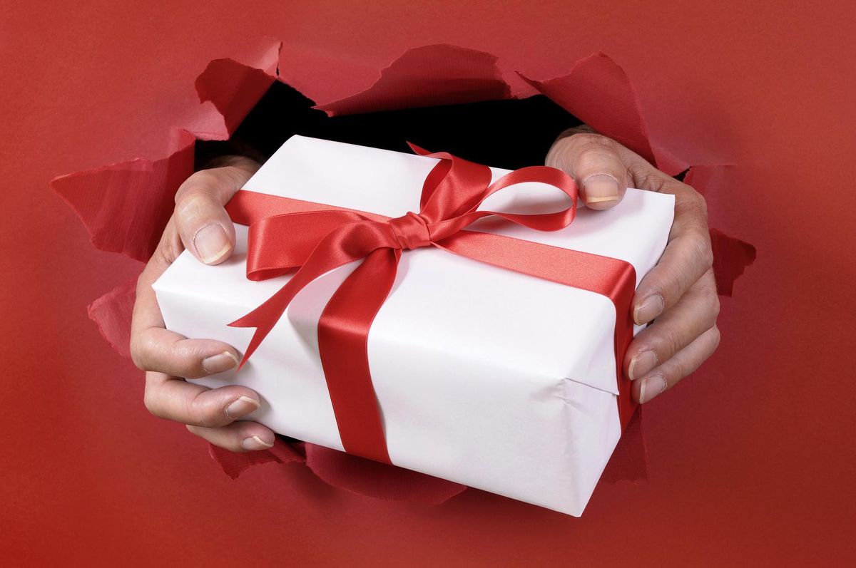 White gift with ribbon being delivered