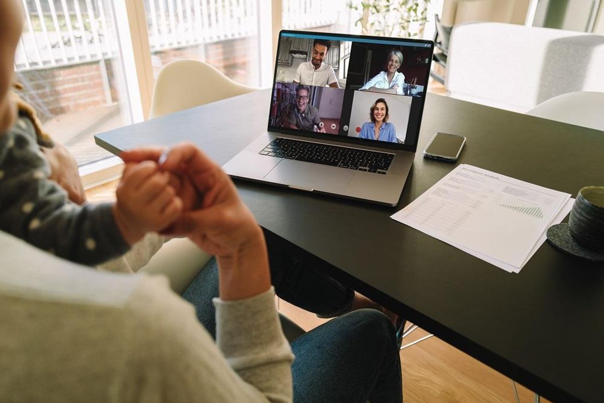 Woman at home video conferencing with colleagues