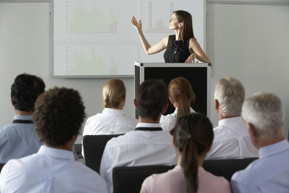 Woman giving corporate investor pitch articulating her product's val prop