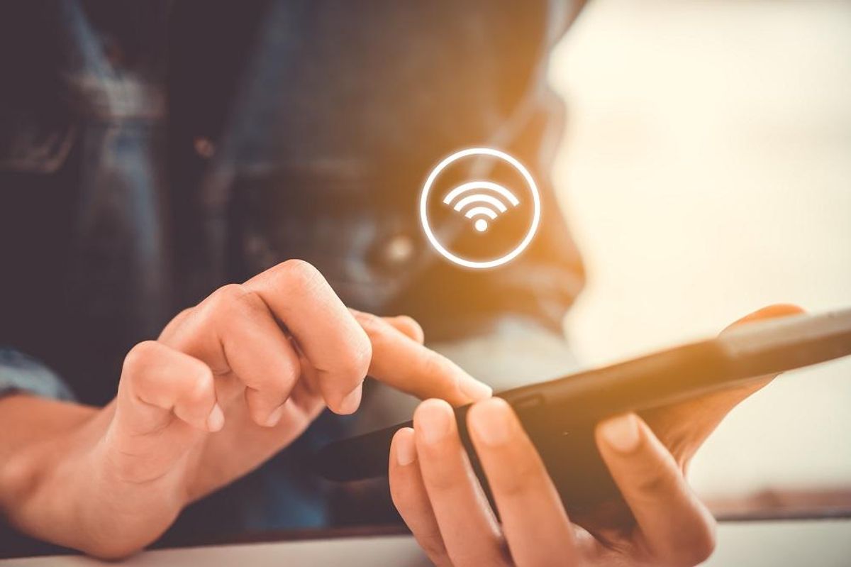 Woman hand using smartphone with wifi icon