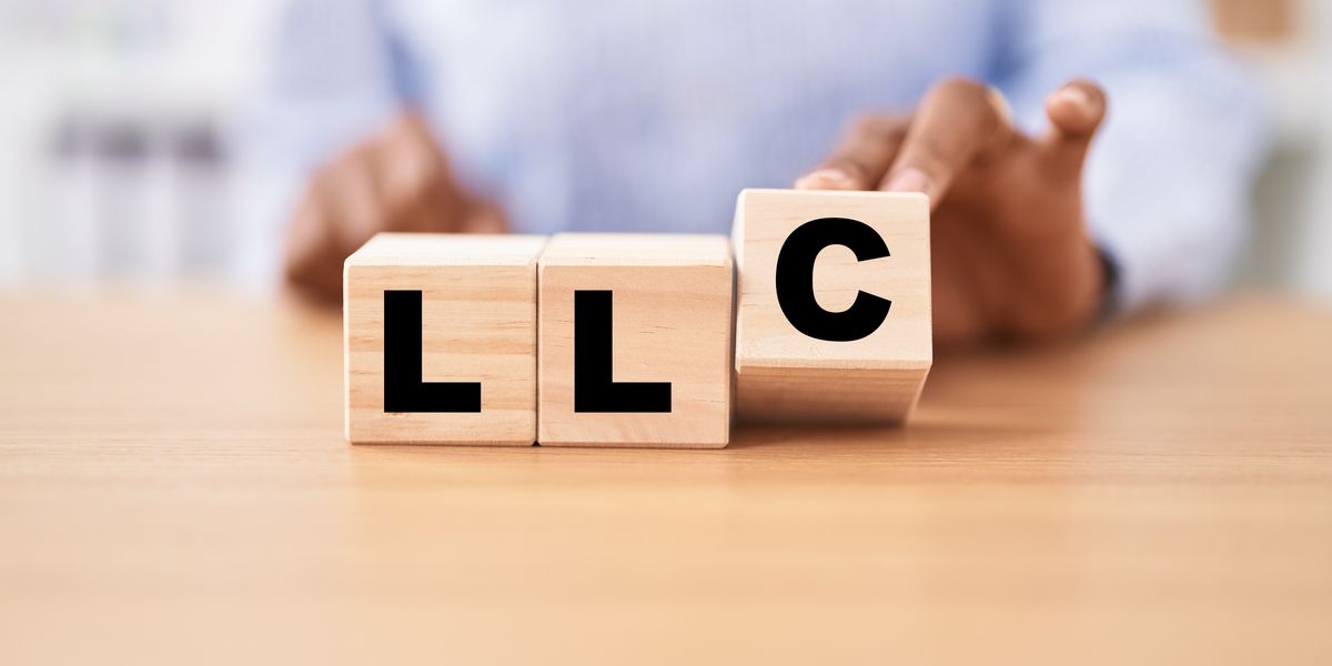 Woman holding cubes with llc word on the table