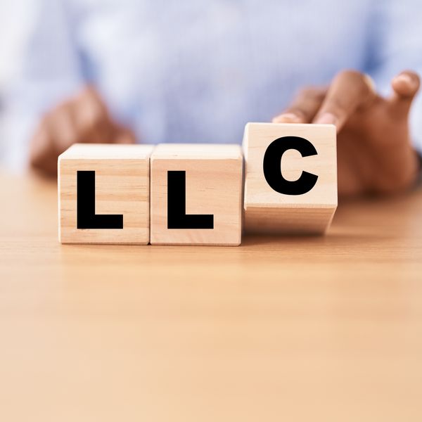Woman holding cubes with llc word on the table