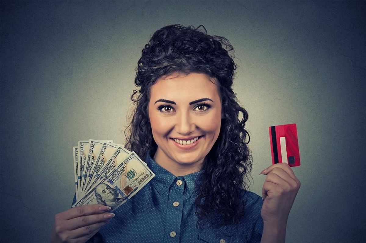 woman holding showing credit card and cash dollar