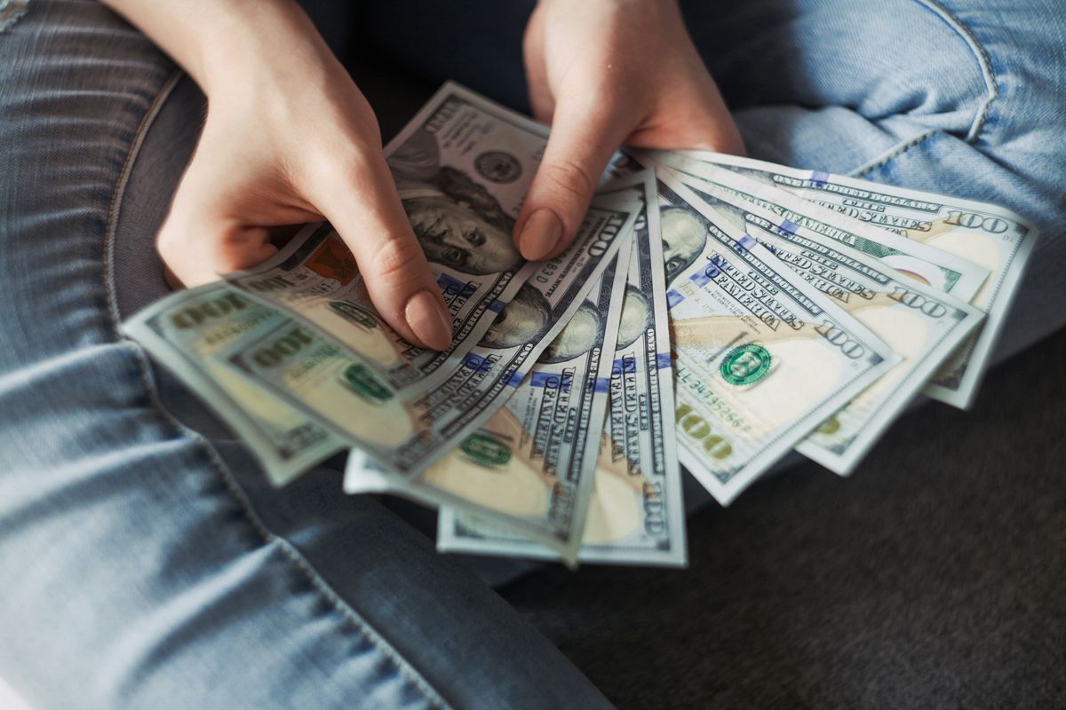 Woman looking at cash from her paycheck