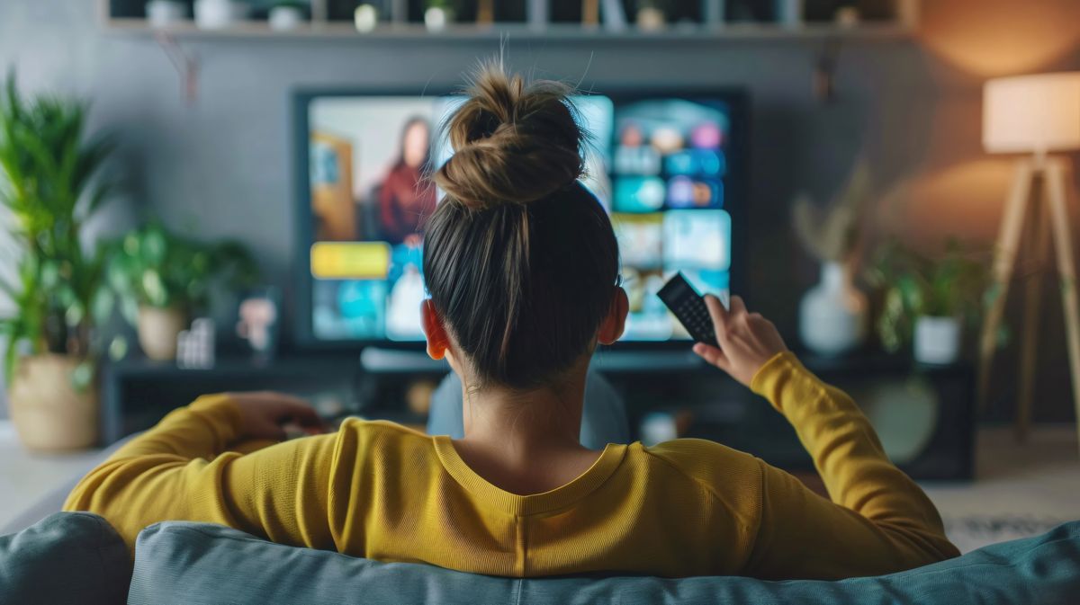 Woman relaxing on the couch, choosing a TV show