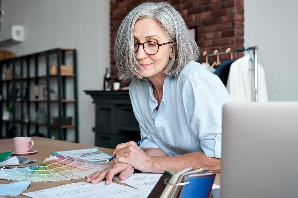 Woman small business owner draws sketches in office