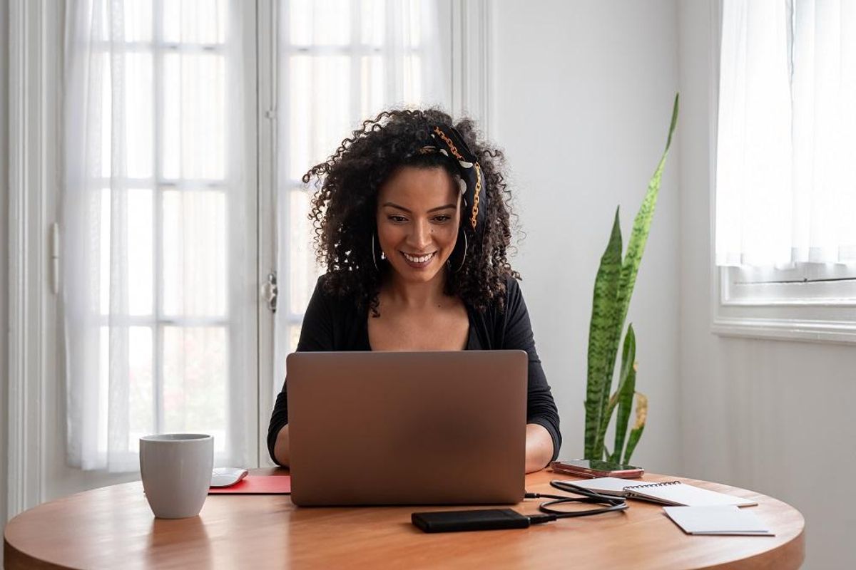 woman working at home with laptop and documents
