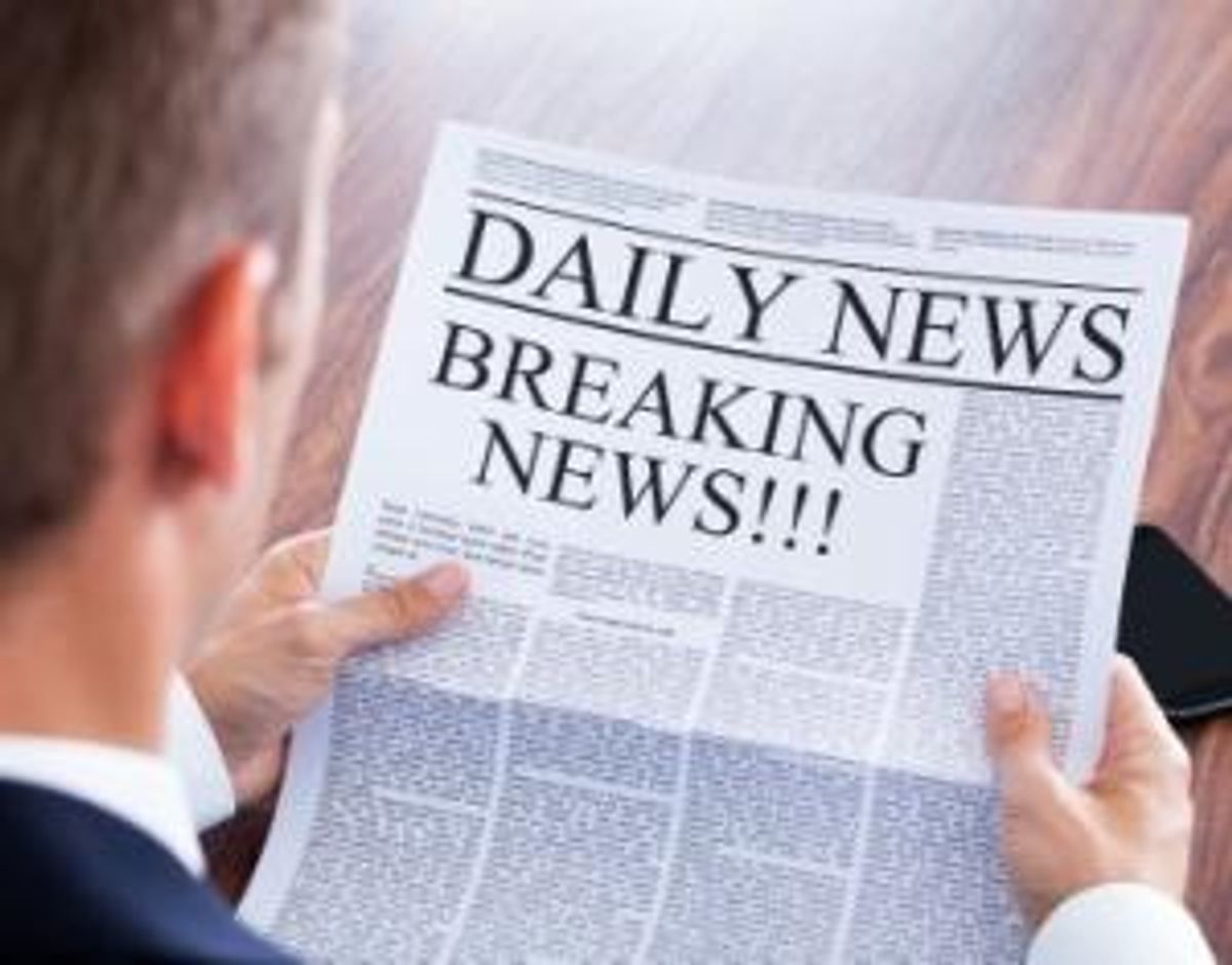 Young Businessman Reading Breaking News On Newspaper