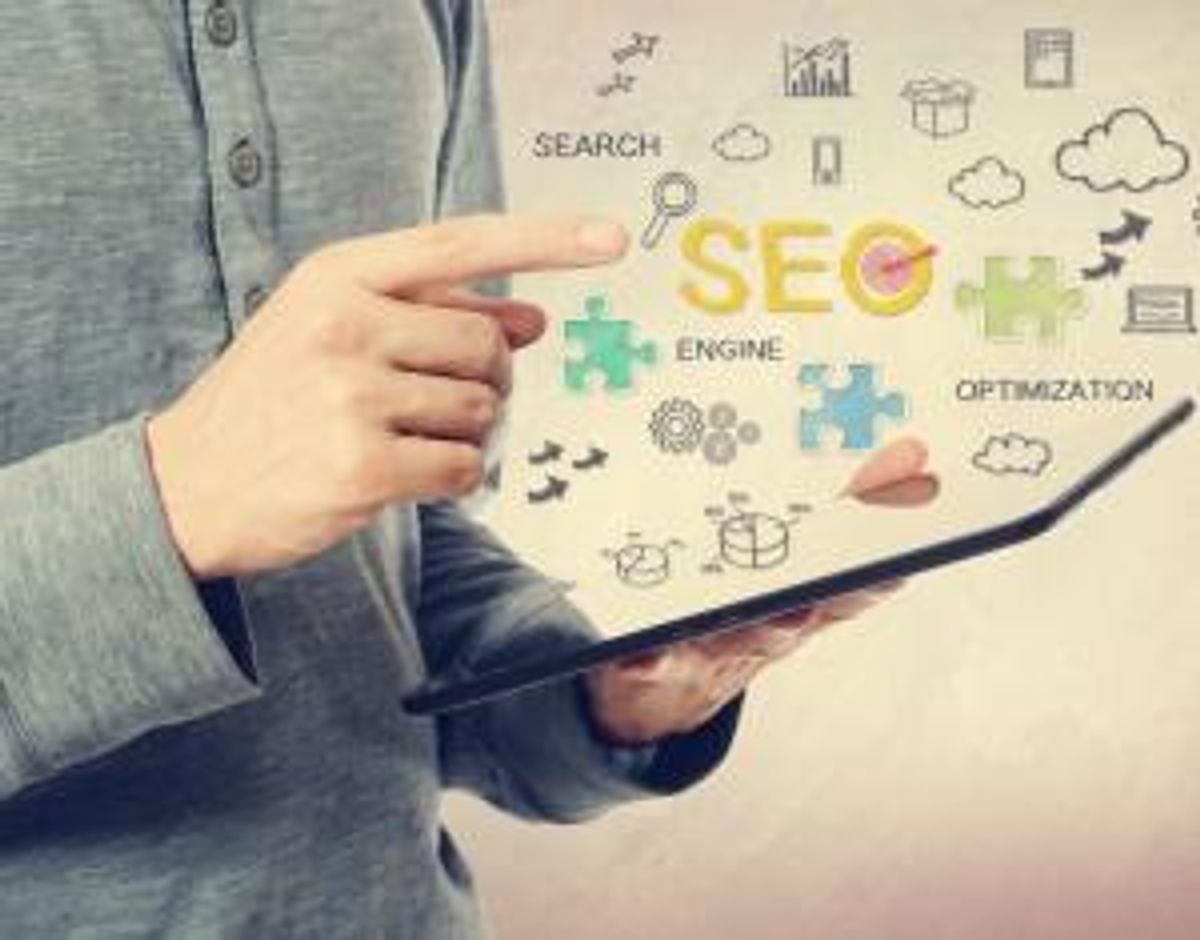Young man pointing at SEO concept over a tablet