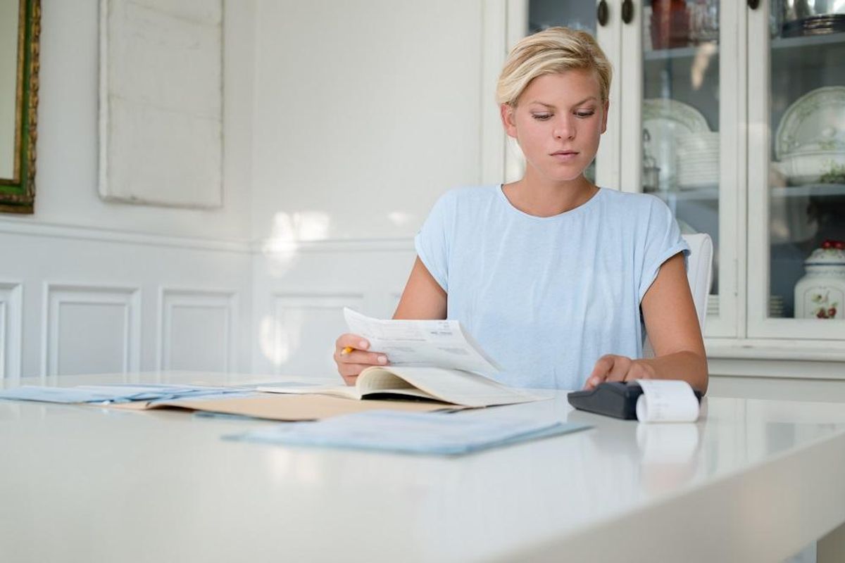 Young woman checking bills and doing budget